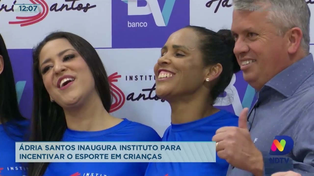 Adria sorri junto a uma mulher e um homem em inauguração do Instituto.