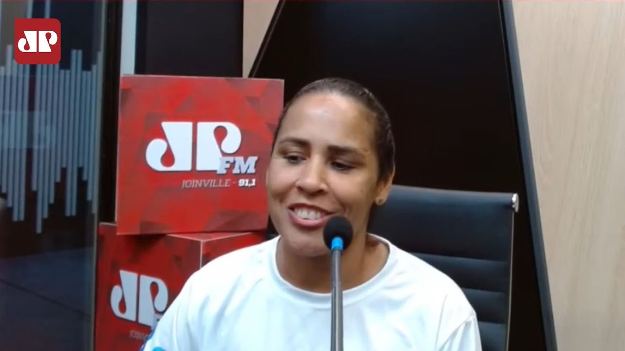 Adria Santos fala ao microfone na Jovem Pan FM.