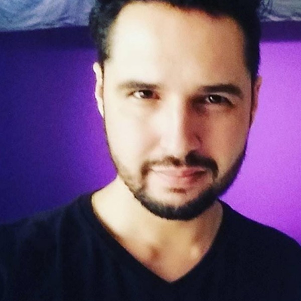 Foto de Sérgio, que tem a cor da pele branca, cabelos escuros e curtos, barba e bigode ralos.