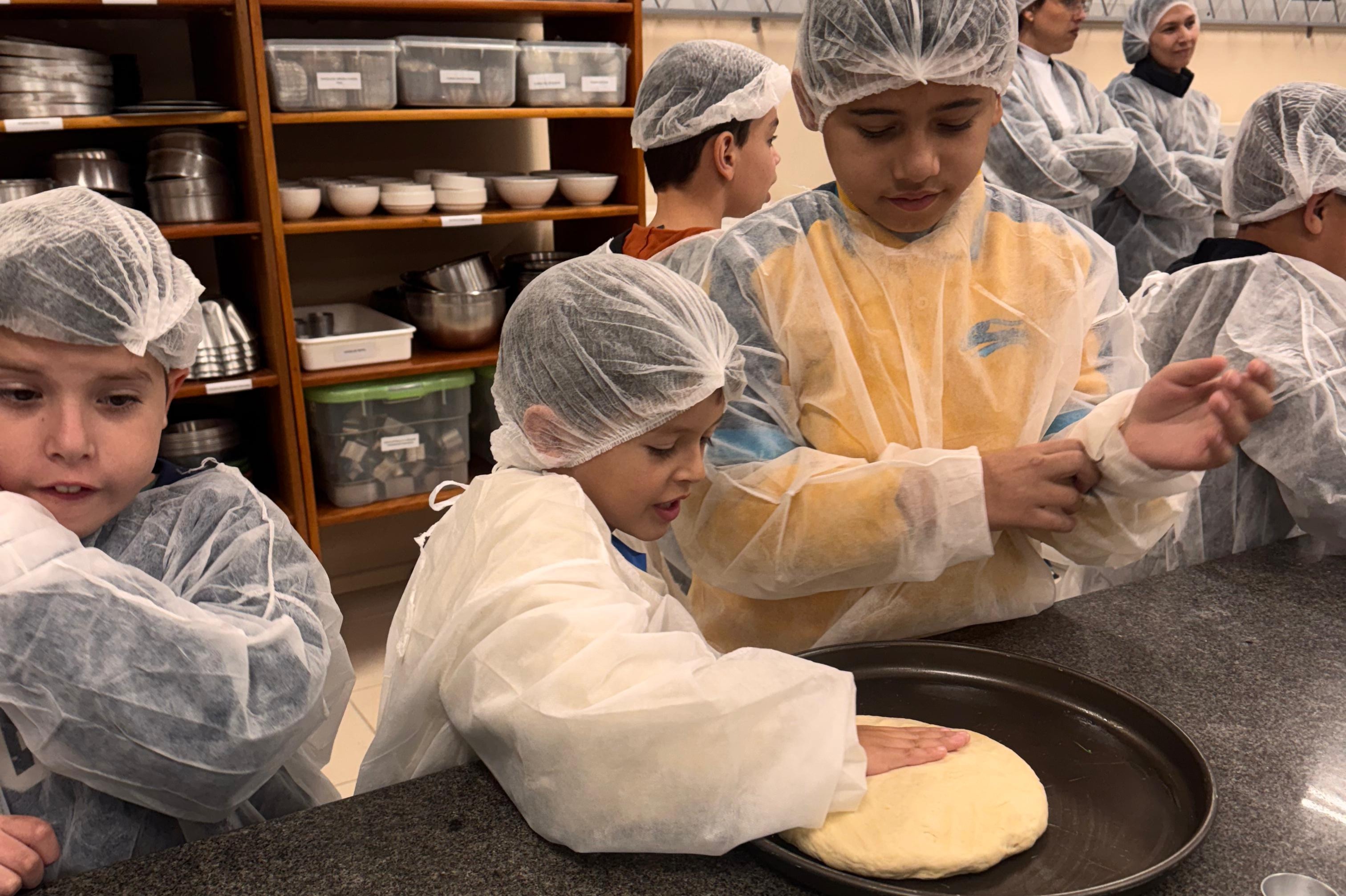 Alunos do Instituto produzindo pizza na Colônia de Férias