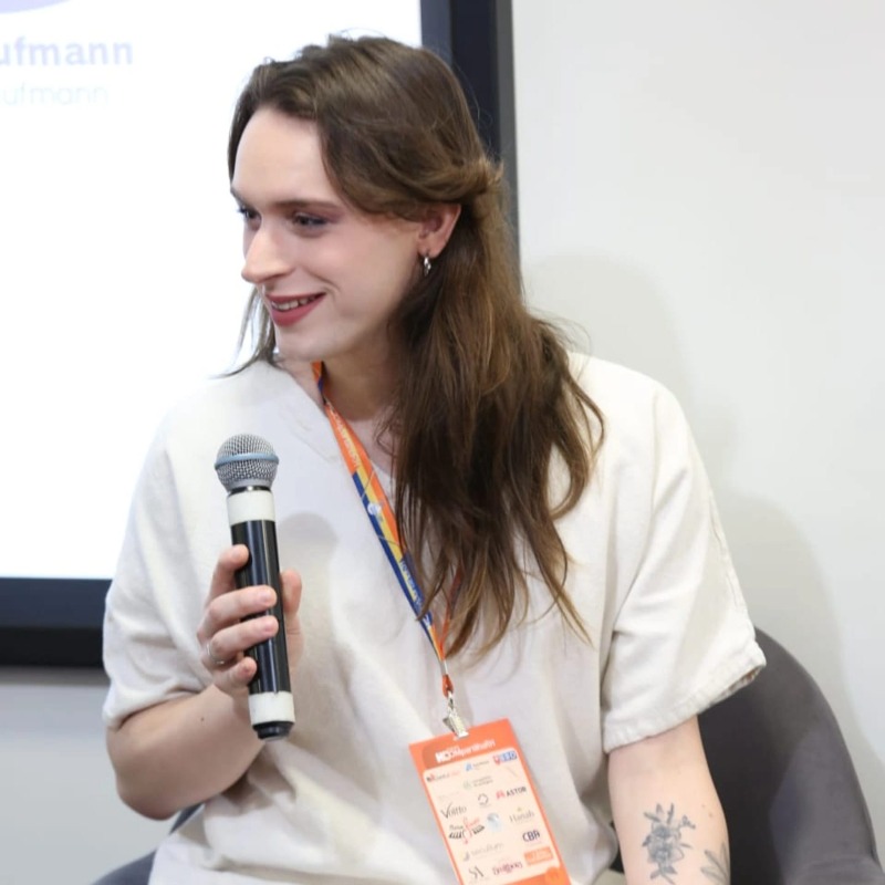 Vini pele branca, cabelos longos, segurando um microfone